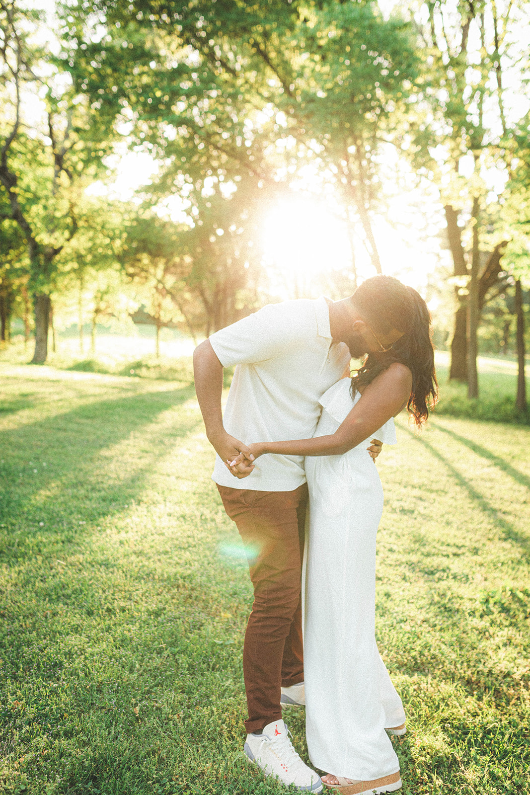 A loving couple embraces in a photo session at Percy Warner Park in Nashville, capturing romance against the scenic backdrop, featuring the iconic Parthenon.