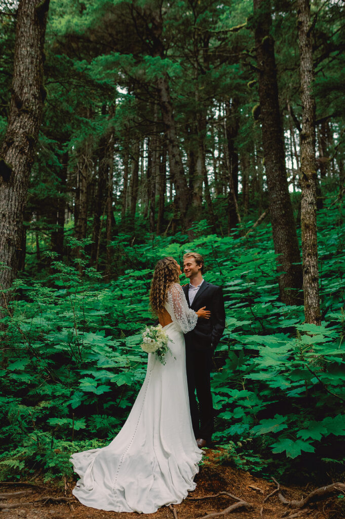 Happy couple enjoying a peaceful moment in the enchanting Alaskan forest. Embraced by towering trees and surrounded by nature's beauty, the duo shares a joyful connection. Experience love in the heart of Alaska's pristine wilderness with this picturesque scene of togetherness.